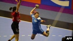 Казахстанская гандболистка Валерия Караева с мячом (в голубом). Джакарта, 16 августа 2018 года. 