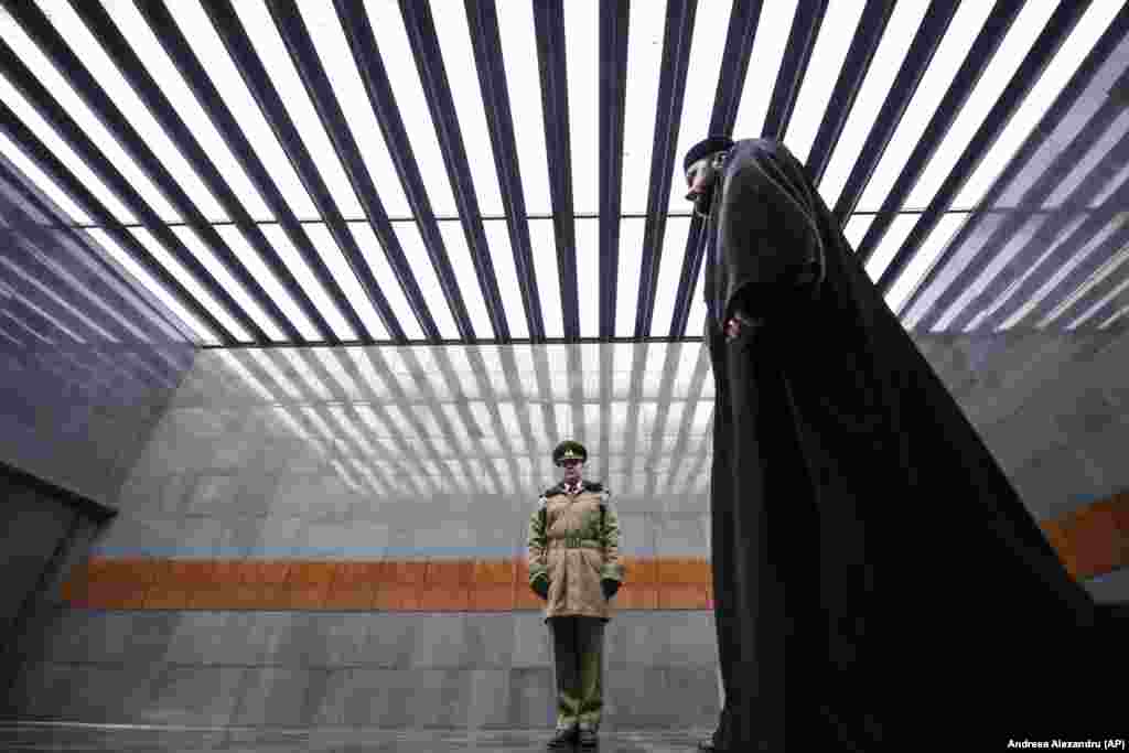An Orthodox priest walks after paying respects at the Holocaust memorial in Bucharest, Romania, on January 27.&nbsp;(AP/Andreea Alexandru)