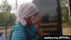 Женщина плачет у памятника погибшим в 2011 в Темирском районе Актюбинской области полицейским. Шубарши, 22 июня 2012 года.