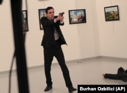 The gunman is pictured moments after shooting Russian Ambassador to Turkey Andrei Karlov at a gallery in Ankara, Turkey, on December 19.