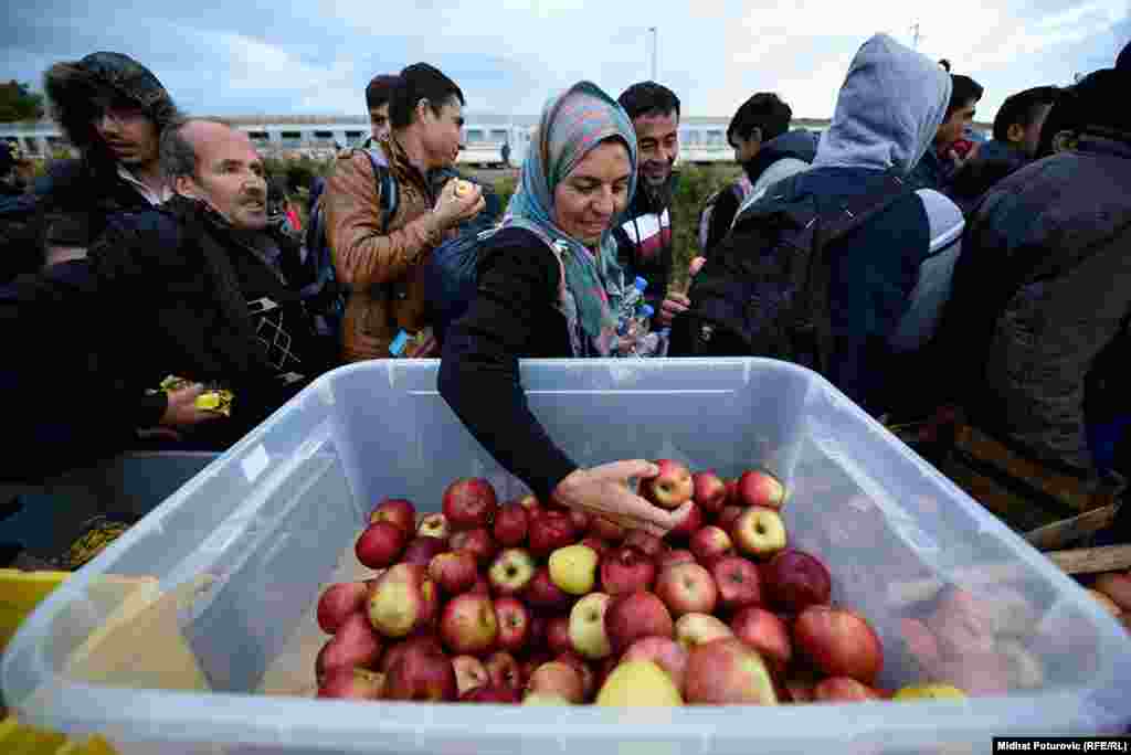 Izbjeglice uzimaju hranu koju su za njih pripremili volonteri