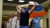 Александр Шпрыгин, глава Всероссийского общества болельщиков, держит флаг перед вылетом из Москвы на чемпионат мира по футболу во Франции. 18 июня 2016 года.