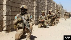 Afghan National Army commandos take position during a military operation in Helmand Province on October 9.