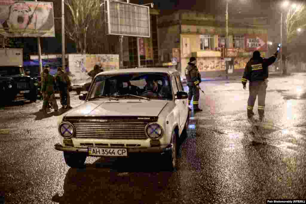 Separatist militiamen stop a car for inspection.