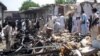 People survey the site of a bomb blast in the Pusht area of Bajaur's Salarzai district in July.