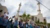 Residents of the Arab Israeli town of Abu Ghosh wave the Chechen flag during the dedication ceremony for the Akhmad Kadyrov Mosque in 2013. The building, which dominates the skyline, was funded by Akhmad's son and current Chechen leader Ramzan Kadyrov. 