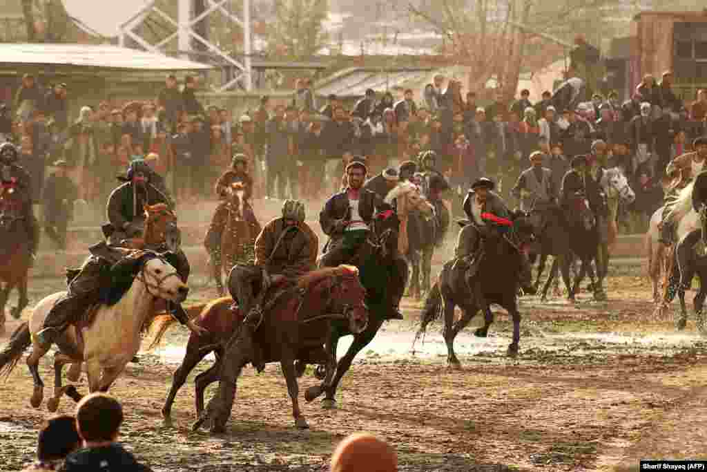 Afghan horsemen compete during a game of the traditional sport of buzkashi in Badakhshan Province. The ancient game -- an Afghan national sport -- is played between two teams of horsemen competing to throw an animal carcass into a circle. (AFP/Sharif Shayeq)