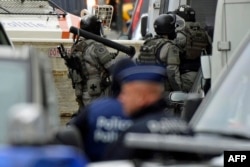Armed special forces arrive at the scene during a house search in the Molenbeek district of Brussels, November 16, 2015
