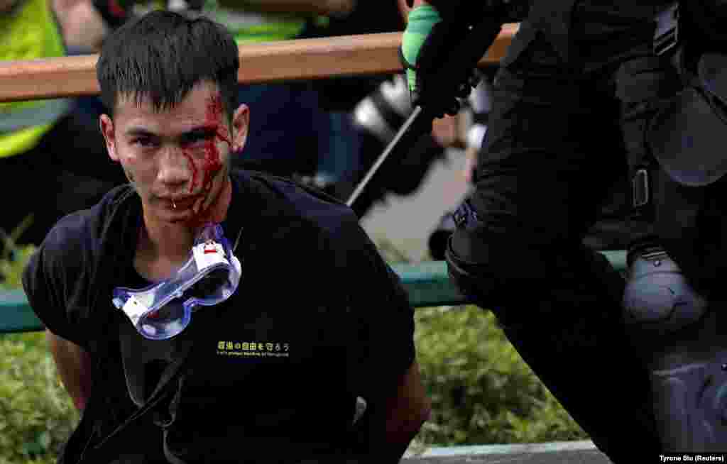 Поліція затримує протестувальників, які намагаються покинути студентське містечко Гонконгського політехнічного університету під час сутичок із поліцією Гонконгу, 18 листопада 2019 року