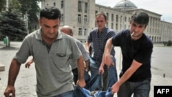 Men carry the body of a man killed by a shell in the town of Gori on August 12