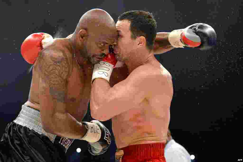 Wladimir Klitschko of Ukraine (right) punches Tony Thompson from the United States during a successful defense of his IBF, WBA, and WBO world heavyweight boxing titles on July 7. (AFP/Fabrice Coffrini)