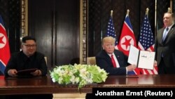 Printre documentele pe care le-ar fi luat Donald Trump de la Casa Albă s-ar afla și mesaje de la lideri străini. În imagine: președintele SUA (dreapta) și liderul din Coreea de Nord, Kim Jong Un, în Singapore, în 2018. 