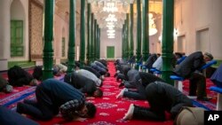 Uyghurs and other Muslims pray at a mosque in Kashgar in western China's Xinjiang Province, as seen during a government organized trip for foreign journalists on April 19. 