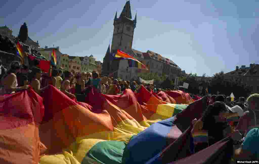 People hold up a large rainbow flag as they march across Prague&#39;s Old Town Square during the third gay-pride festival in the Czech capital on August 17. (AFP/Michal Cizek)
