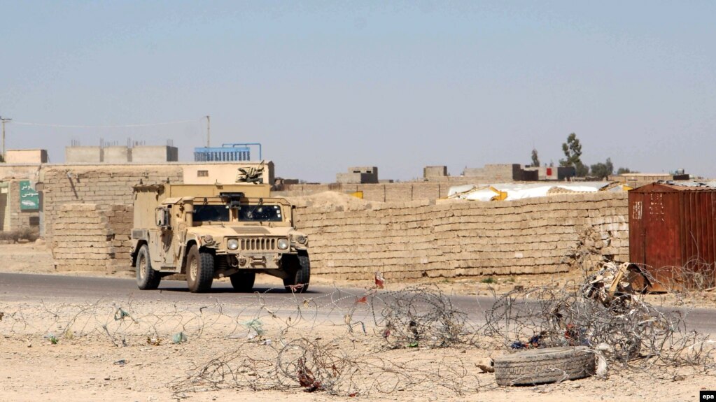Afghan security officials patrol in an area during an operation against Taliban militants in Nad Ali district of Helmand province, March 11, 2017