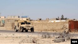 Afghan security officials patrol in an area during an operation against Taliban militants in the Nad Ali district of Helmand Province on March 11. 