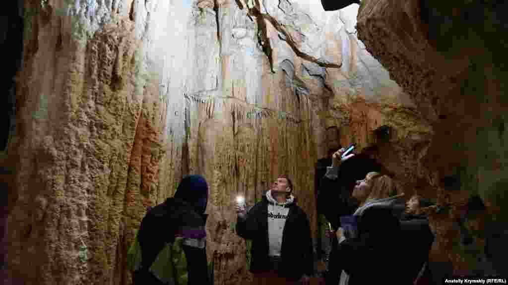 Туристи фотографують сталактитові склепіння однієї з галерей на маршруті