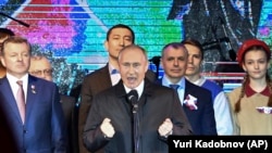 UKRAINE -- Russian President Vladimir Putin, center, gestures while speaking at an outdoor concert in Crimea's regional capital of Simferopol, Crimea, Monday, March 18, 2019. 