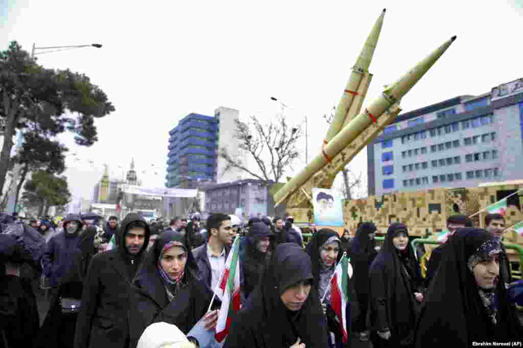 Iranians walk past a missile during a rally in Tehran. Banners held by marchers or hung in the streets bore slogans including &quot;Death to America,&quot; &quot;Death to Israel,&quot; and &quot;40 years of challenge, 40 years of U.S. defeats.&quot;