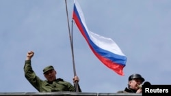 A man holds a Russian flag on the roof of the Ukrainian naval headquarters in Sevastopol on March 19.