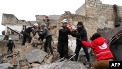 "Helmetat e Bardha" dhe vullnetarët kërkojnë për fëmijë të mbijetuar në rrënojat e një ndërtese të shkatërruar nga sulmet ajrore në Idlib të Sirisë