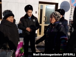 Родственники Майры Рысмановой, совершившей самосожжение жительницы города Шу, беседуют с полицейскими у здания генеральной прокуратуры. Астана, 7 декабря 2016 года.