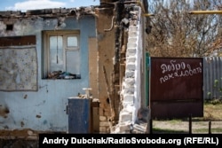 Один з повністю згорілих будинків у селі з написом на воротах «Добро пожаловать!»
