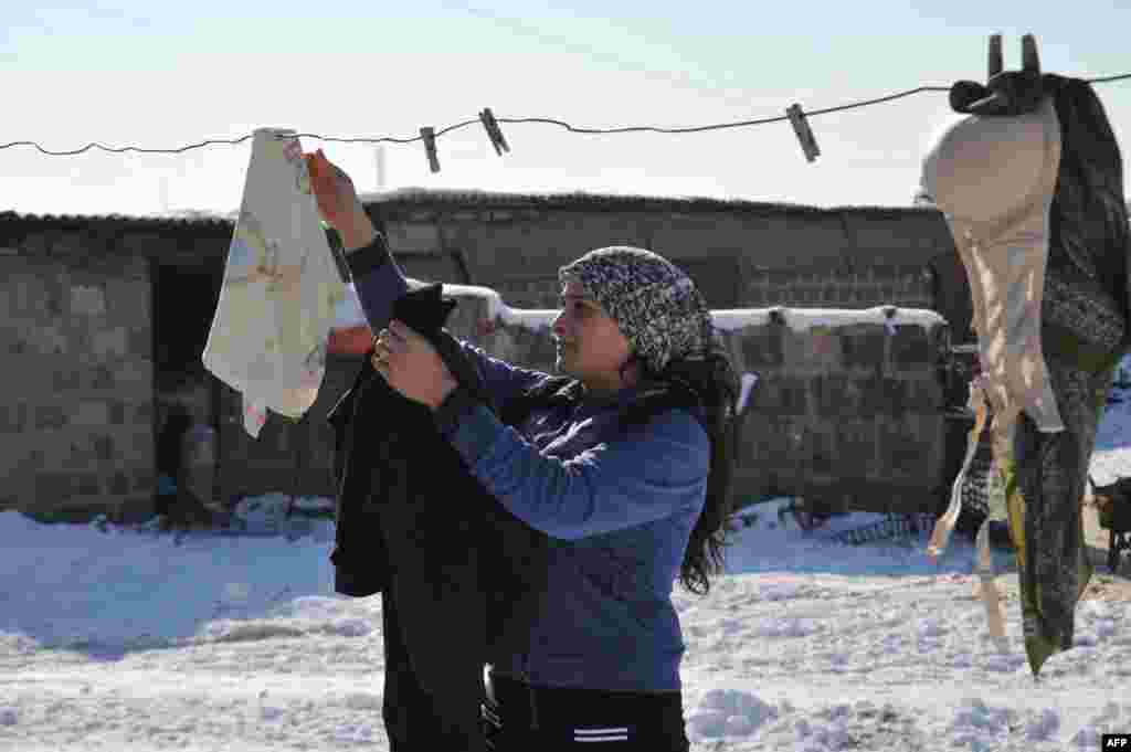 Лиана Амарян развешивает белье у своего каменного дома 