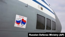 A Russian military transport plane with a sign reading "From Russia with love" is loaded with medical supplies and disinfection equipment before a flight to Serbia, at Chkalovsky military airport outside Moscow, on April 3.