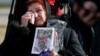 A woman reacts during a ceremony for a memorial site to the victims at Boryspil International Airport outside Kyiv on February 17.