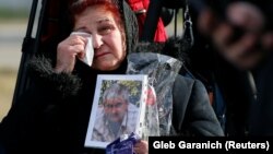 A woman reacts during a ceremony for a memorial site to the victims at Boryspil International Airport outside Kyiv on February 17.