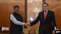 Indian Minister for Petroleum and Natural Gas Dharmendra Pradhan (L) shakes hand with US Energy Secretary Rick Perry during a press conference in New Delhi on April 17, 2018. Perry is in India aiming to promote liquefied natural gas (LNG) and other energy