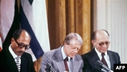 Anvar Szadat egyiptomi elnök, Jimmy Carter, az Egyesült Államok elnöke és Menáhém Begin izraeli miniszterelnök aláírja a békemegállapodást Washingtonban 1978. szeptember 18-án