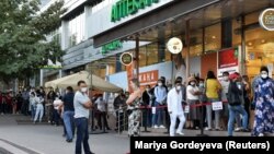 People wait in line outside a pharmacy in Almaty, Kazakhstan, on June 29.