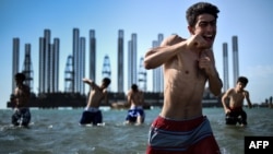 Azerbaijan -- Teenagers from a boxing school take part in a training session in the Caspian Sea near Soviet oil rigs in the Azerbaijani capital Baku, June 28, 2015