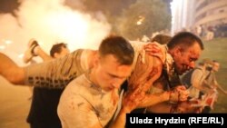 Belarus - people carry an injured in Minsk / Demonstrators carry injured man during a protest after polls closed in Belarusian presidential election, in Minsk on August 9, late night, 2020.