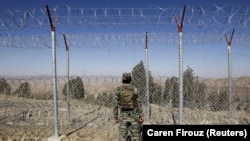 A soldier stands guard along the border fence at the Angoor Adda outpost on the border with Afghanistan in South Waziristan tribal district in western Pakistan.