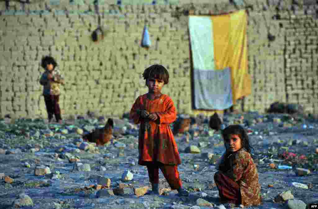 Afghan internally displaced children look on outside their temporary house on the outskirts of Jalalabad in Nangarhar Province. (AFP/Noorullah Shirzada)