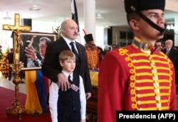 Аляксандар Лукашэнка з сынам Мікалаем на разьвітаньне з Уга Чавэсам, Каракас, 8 сакавіка 2013