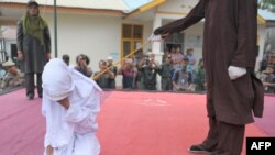 An Acehnese woman in Indonesia is caned by a religious officer for spending time in close proximity to a man who was not her husband, a crime under Shari'a law, in February.