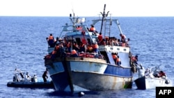 Сделанный в августе этого года снимок судна с мигрантами, которым оказывают помощь итальянские военные
