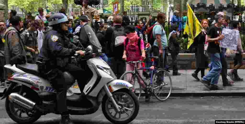 A police officer rides alongside Occupy Wall Street protesters as they march from New York City's Bryant Park to Union Square.