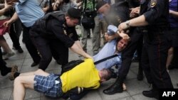 Полицейские разнимают православного активиста и сторонника прав геев возле здания Госдумы в Москве. 11 июня 2013 года. 