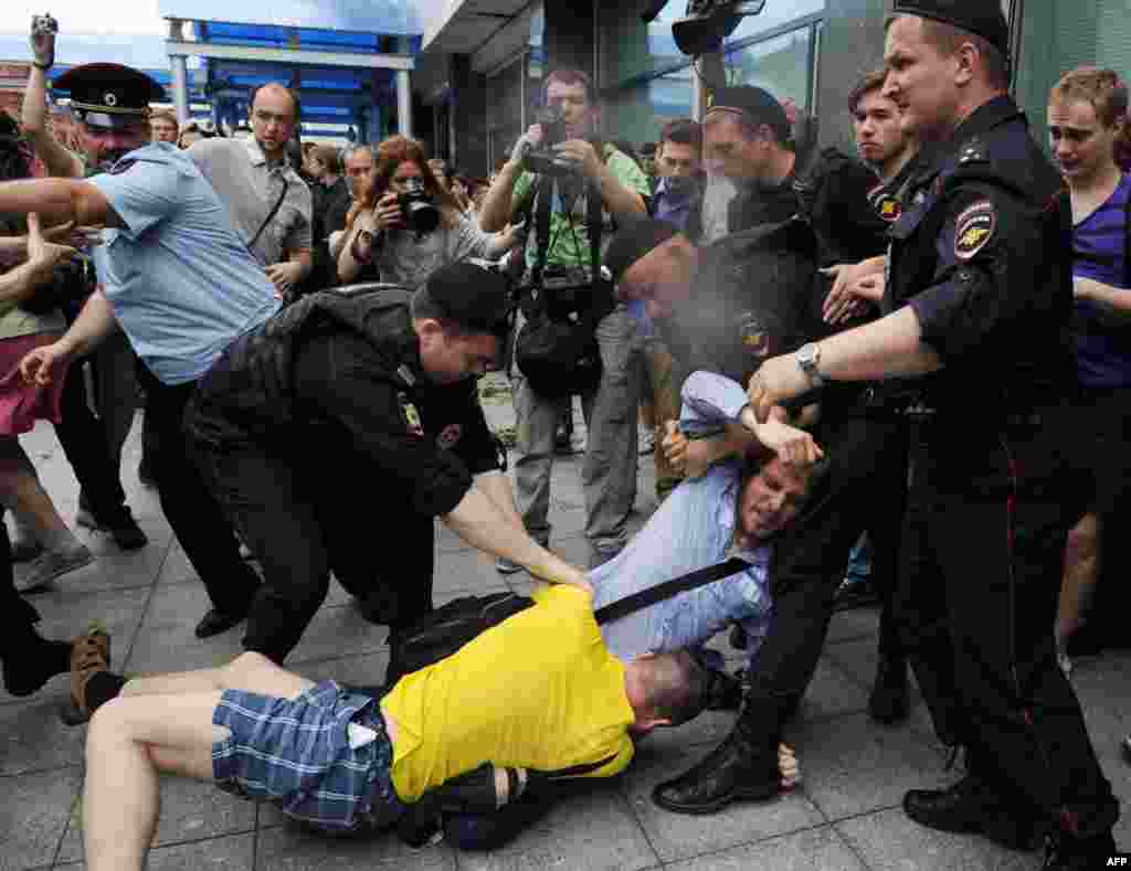 Police officers separate an Orthodox activist and gay-rights activist outside the State Duma.