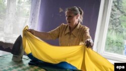 Donetskdə seçkiyə hazırlıaşan qadın Ukrayna bayrağını ütüləyir