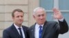 French President Emmanuel Macron, left, shake hands with Israeli Prime Minister Benjamin Netanyahu as he waves waves good-bye to the media after a meeting at the Elysee Palace in Paris, France, Sunday, July 16, 2017.