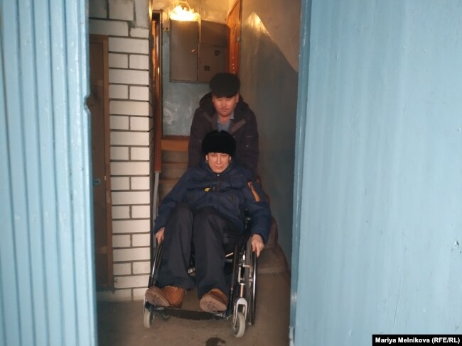 Эрик Жумабаев и его помощник Орынбай Охасов на выходе из подъезда.