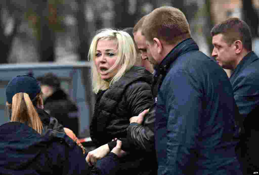 Policemen restrain Maria Maksakova, the wife of former Russian lawmaker Denis Voronenkov, as she reacts near his body in the center of Kyiv on March 23. Voronenkov was gunned down in broad daylight. The attacker was shot in the ensuing gunbattle with Voronenkov&#39;s lone bodyguard and apprehended by police on the street nearby. He later died in hospital, officials said, but there was initially no word of his identity. (AFP/Sergei Supinsky)