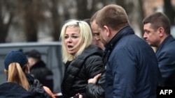 Полицейские уводят Марию Максакову, жену Дениса Вороненкова, убитого в центре Киева. 23 марта 2017 года.