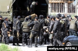 Вооруженные полицейские после спецоперации в микрорайоне «Акселькент» в Алматы. 30 июля 2012 года.